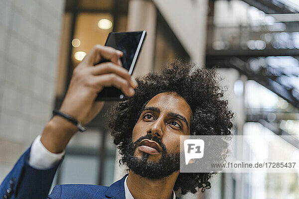 Businessman taking selfie through smart phone