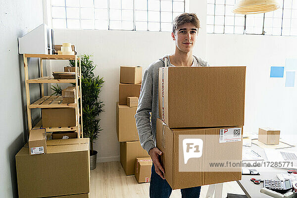 Männlicher Unternehmer trägt Kartons in einem Lagerhaus