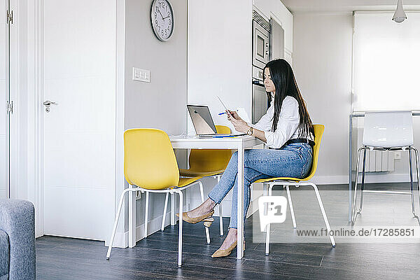 Young woman with laptop working at home office