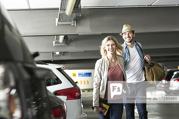 Junges Paar geht über einen Flughafenparkplatz