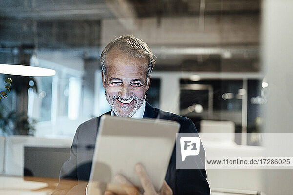 Senior male entrepreneur using digital tablet in office