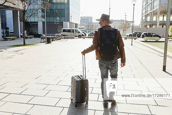 Mann mit Rucksack auf dem Fußweg in den Ferien