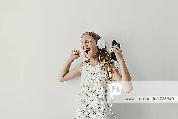 Happy girl listening music through headphones