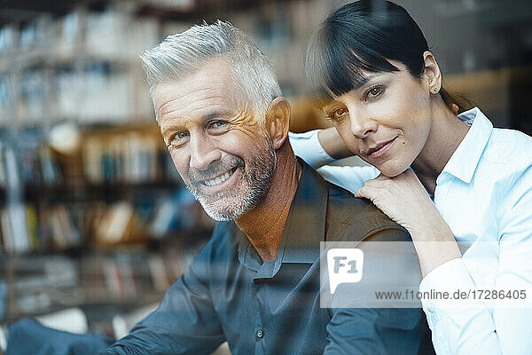 Mature business couple smiling at cafe