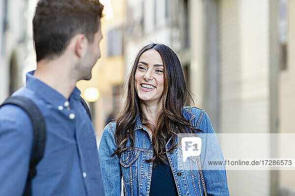 Junge Frau lächelt  während sie einen Mann ansieht