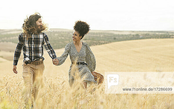 Paar  das sich beim Gehen auf einem Weizenfeld ansieht