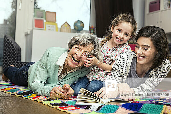Multi-generation family smiling while lying at home