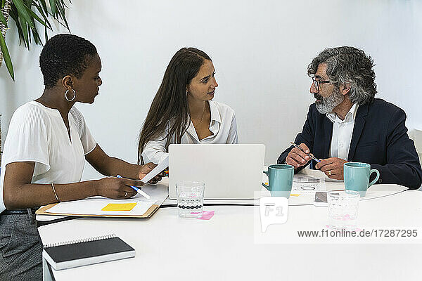 Männliche und weibliche Fachleute diskutieren während einer Besprechung im Büro