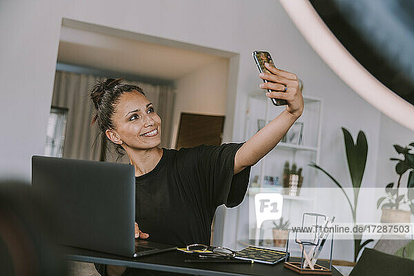 Geschäftsfrau nimmt Selfie durch Smartphone im Büro