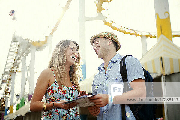 Smiling man with blond woman on vacations at Santa Monica pier