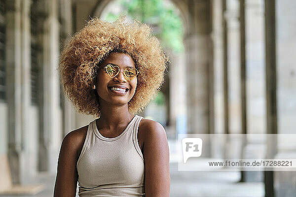 Lächelnde Afro-Frau mit herzförmiger Sonnenbrille