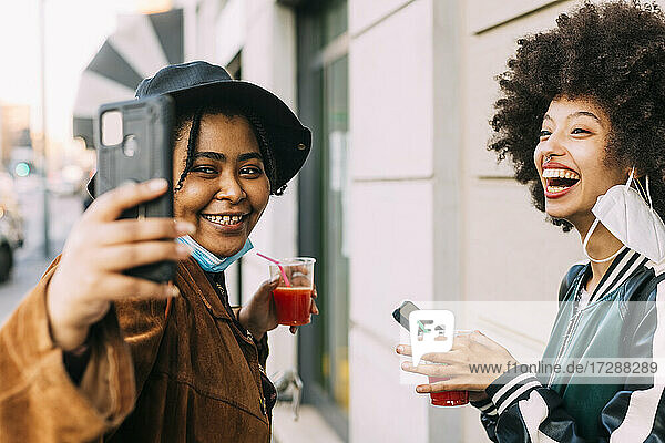 Freunde mit Gesichtsmasken machen ein Selfie mit dem Smartphone