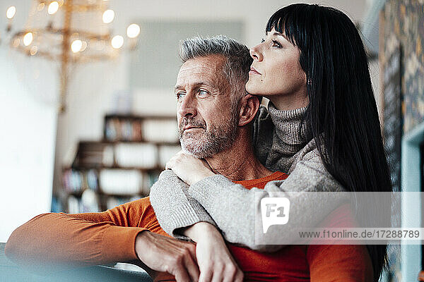 Thoughtful couple looking away in coffee shop