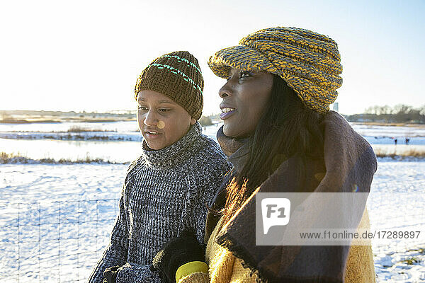 Mother and son wearing knit hat talking with each other during winter