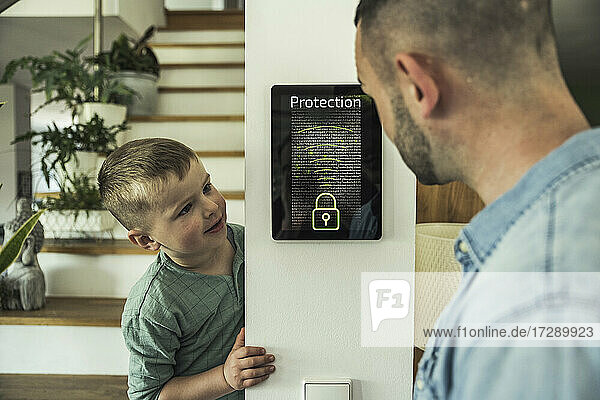 Vater und Sohn sehen sich ein Sicherheits-Tablet im Smart Home an