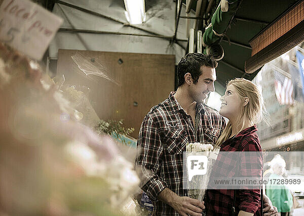 Boyfriend giving flowers to girlfriend at store