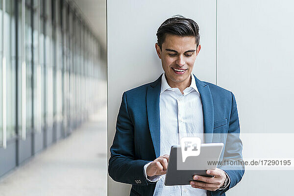 Geschäftsmann benutzt digitales Tablet im Korridor