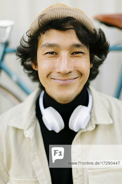 Smiling man with headphones wearing knit hat