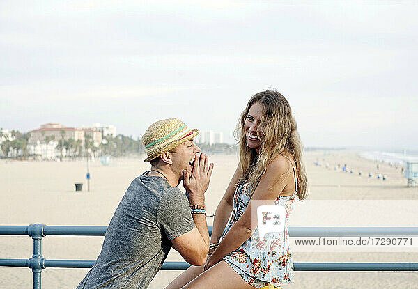 Happy woman with boyfriend on vacations at Santa Monica beach