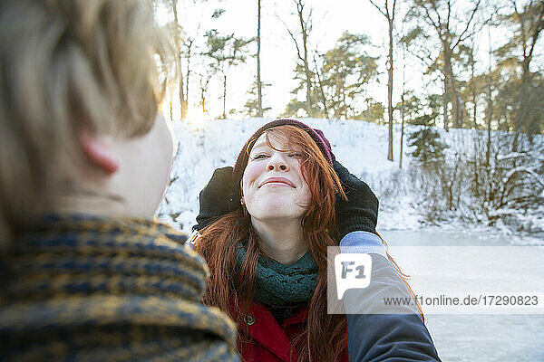 Lächelnde Freundin genießt das Wochenende mit ihrem Freund im Winter