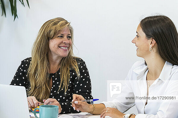 Lächelnde Geschäftsfrauen  die im Büro diskutieren