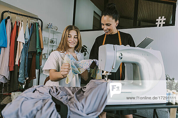 Lächelnde Modedesigner beim Betrachten von Stoffen im Workshop