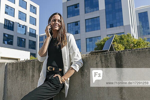 Mature female entrepreneur talking on mobile phone during sunny day
