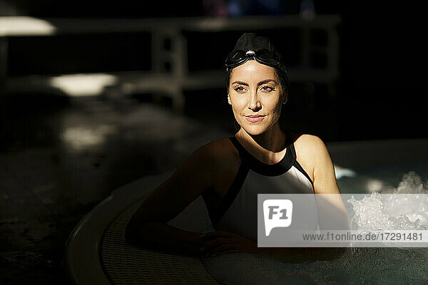 Mature woman with sunlight on face in swimming pool