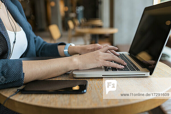Freiberufliche Mitarbeiterin mit Laptop in einem Café