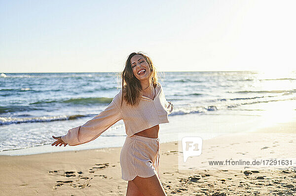 Frau in Freizeitkleidung genießt am Strand an einem sonnigen Tag