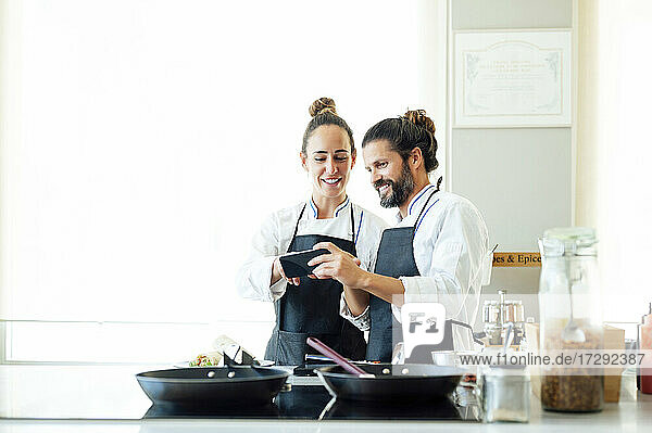 Professional chefs using mobile phone in restaurant