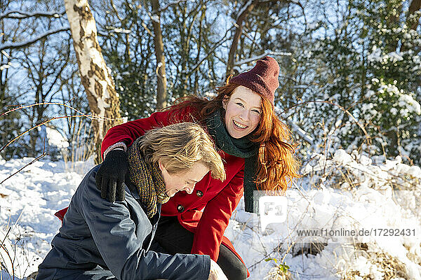 Lächelndes Paar  das sich im Schnee vergnügt
