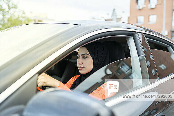 Junge arabische Frau fährt Auto im Freien