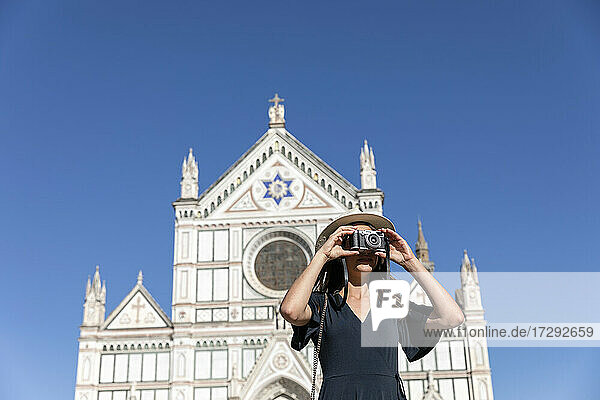 Weiblicher Tourist fotografiert durch die Kamera vor der Basilika Santa Croce  Florenz  Italien
