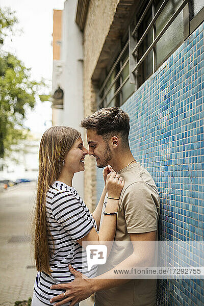 Romantischer Freund und Freundin auf dem Fußweg an der Mauer