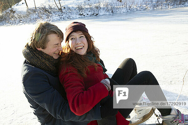 Loving couple having fun while sledding on ice