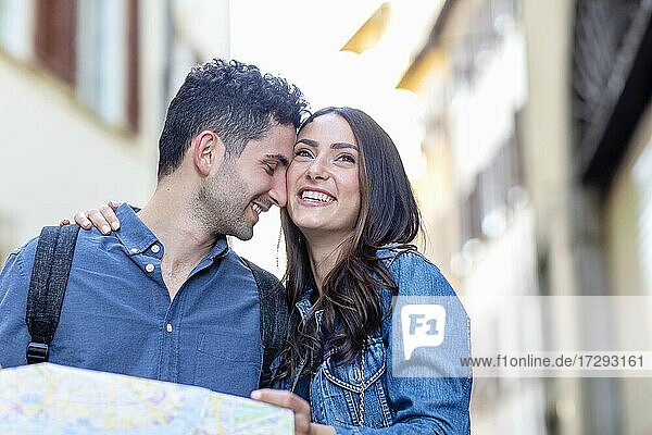 Smiling woman with arm around on man holding map
