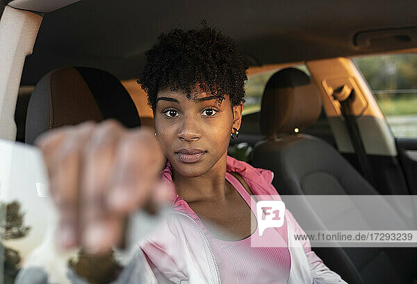 Ernste Frau  die eine Fensterscheibe hält  während sie im Auto sitzt
