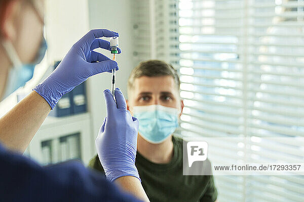 Ärztin bei der Vorbereitung des Impfstoffs für einen Patienten im Impfzentrum während der COVID-19-Krise