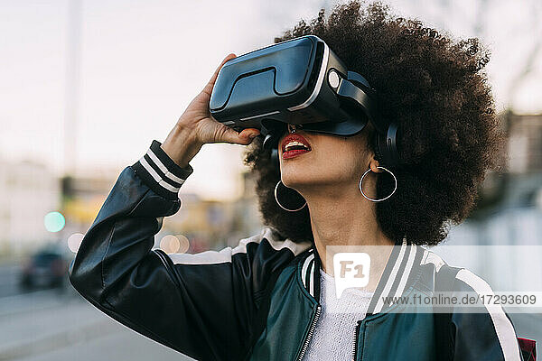 Young afro hairstyle woman using virtual reality headset