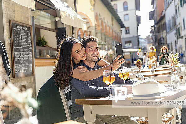 Touristenpaar macht Selfie mit Handy in einem Straßencafé