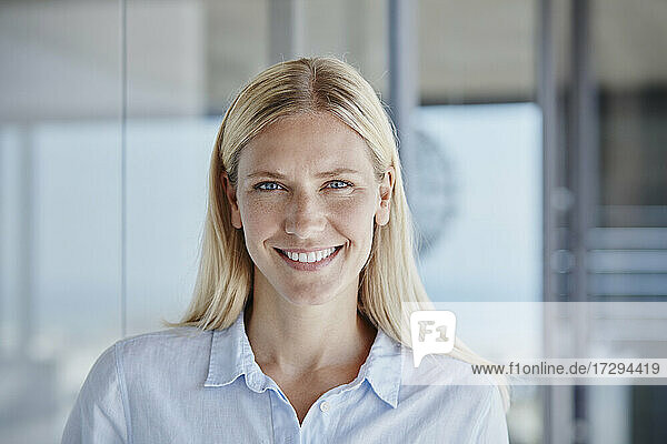 Smiling woman with blond hair at home