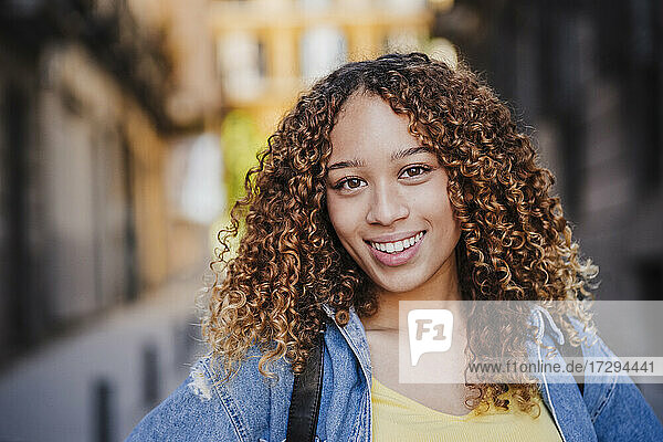 Beautiful woman with curly hair in city