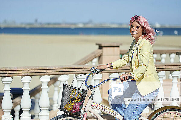 Beautiful woman riding bicycle on sunny day