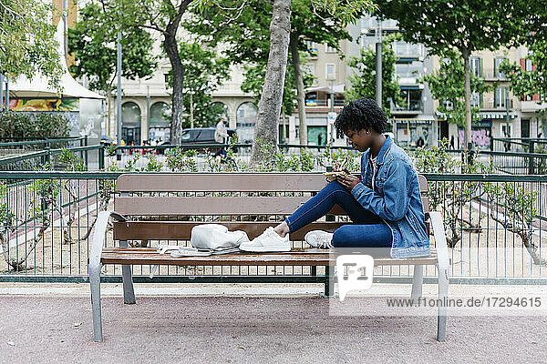 Afro-Frau  die auf einer Bank sitzend schreibt