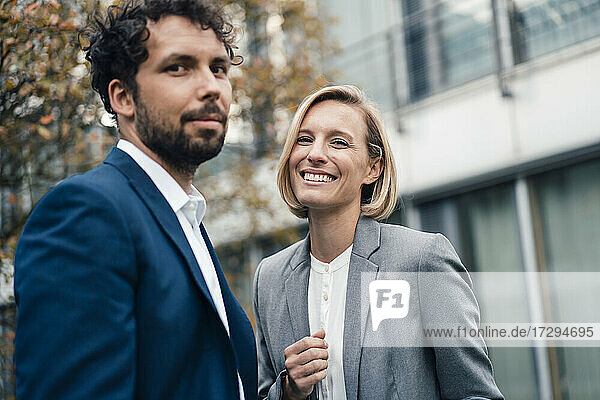 Smiling female entrepreneur standing by female colleague