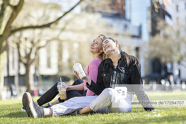 Fröhliche Freundinnen sitzen im Park