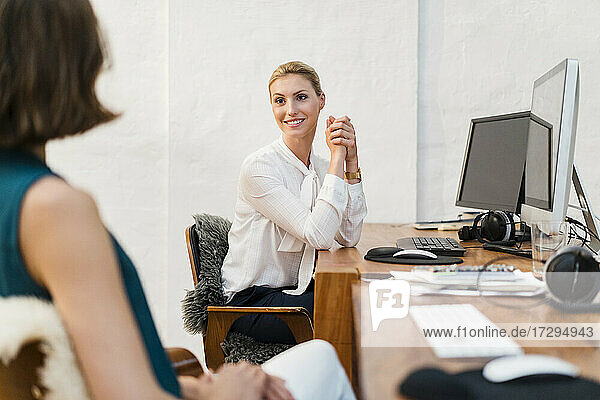 Weibliche Fachkraft sieht Mitarbeiterin an  während sie im Büro diskutiert