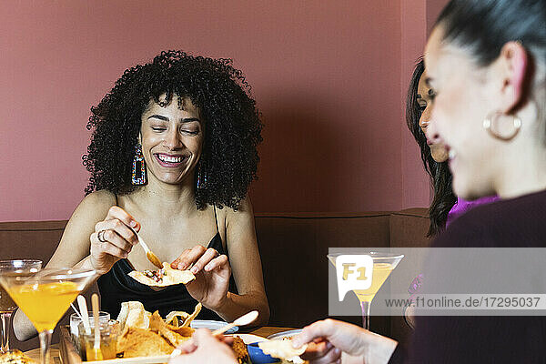 Smiling woman having appetizer with friends in restaurant