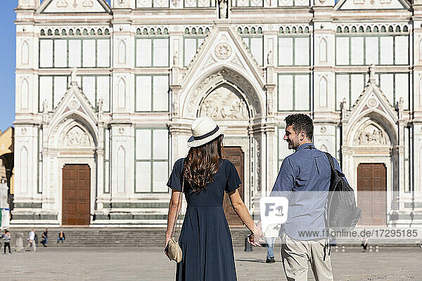 Paar hält sich an den Händen  während es auf der Piazza Di Santa Croce steht  Florenz  Italien